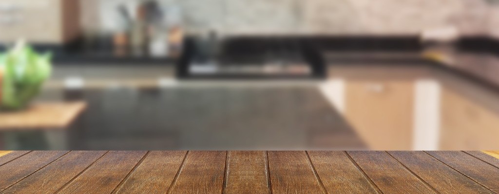 Wood table top on blur the background of the kitchen. - can be used for display your products or promotional and advertising posters